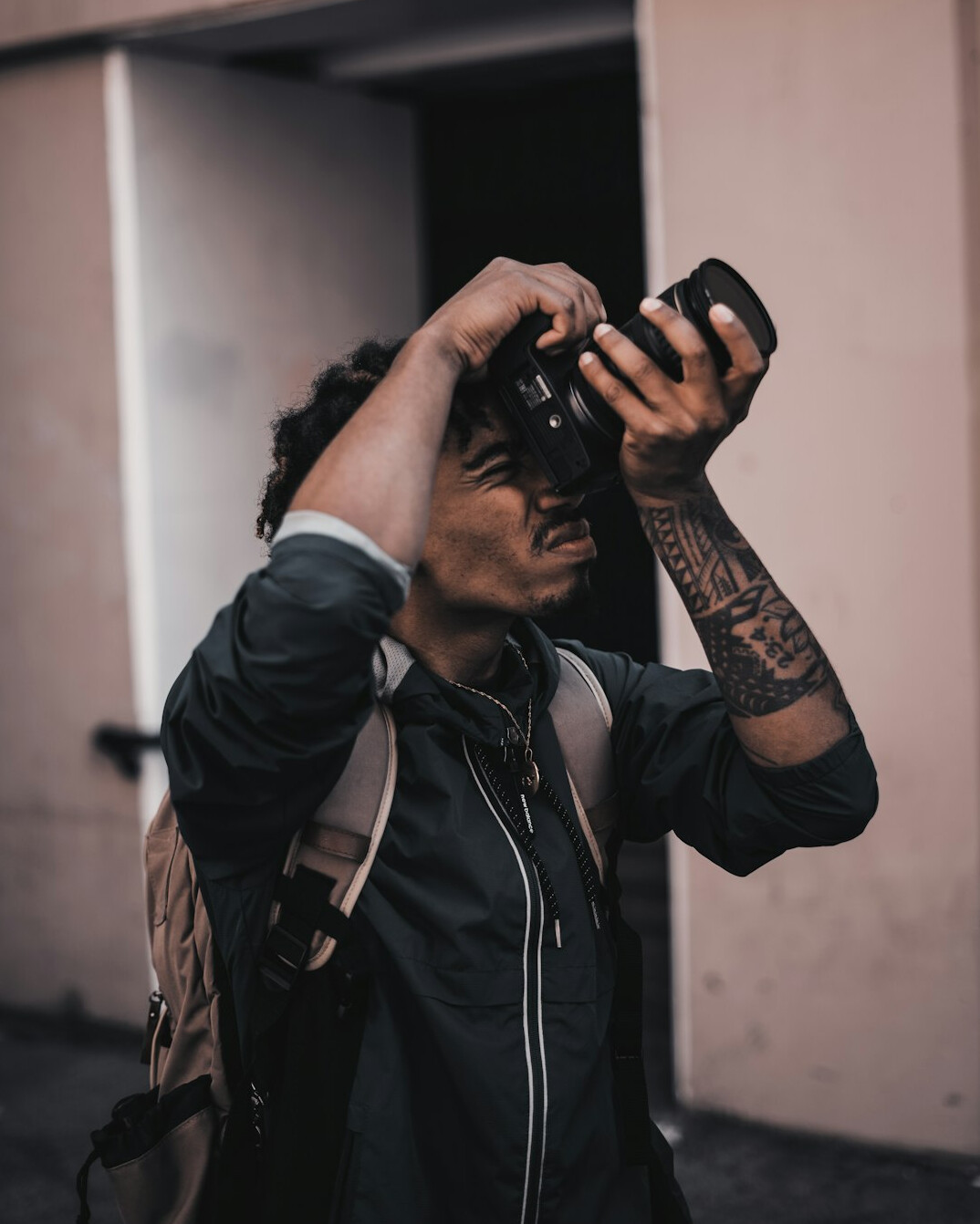 Portrait of a Canadian street photographer holding a camera on a city sidewalk